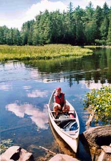 Here goes. Portaging means carrying all your gear, plus canoe, between lakes and rivers. It's heavy, but you don't usually have to go too far. Here, we've just made it through our first.
